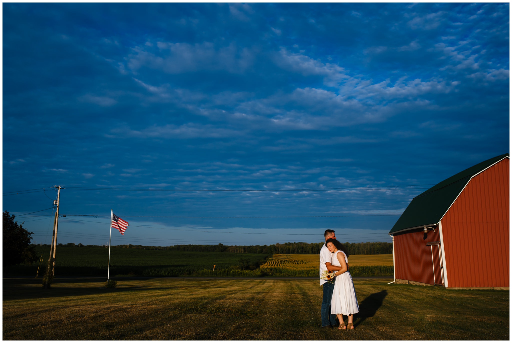 A woman rests her head on her fiancé's
8 shoulder. A red barn is behind them.
