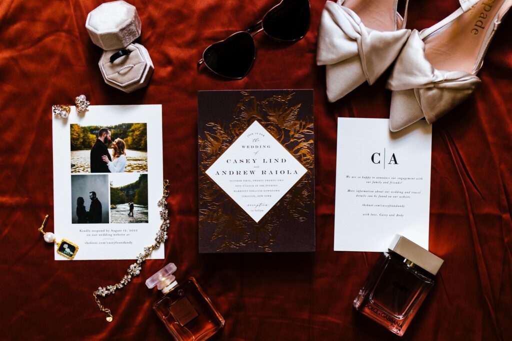 A wedding flatlay that showcases the wedding invitation suite, the bride's shoes, the wedding rings, and other wedding day details.