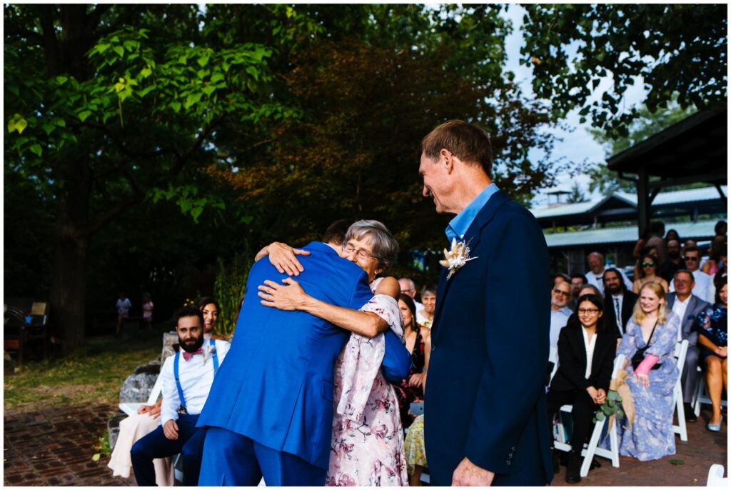The groom hugs his mother at the Ithaca Farmer's Market wedding ceremony.