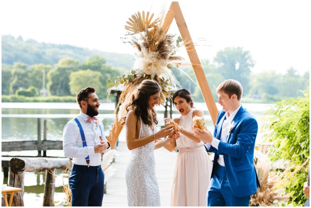 The bride and groom take part in a Bulgarian wedding tradition where they break bread over their heads during their Ithaca Farmer's Market wedding ceremony.