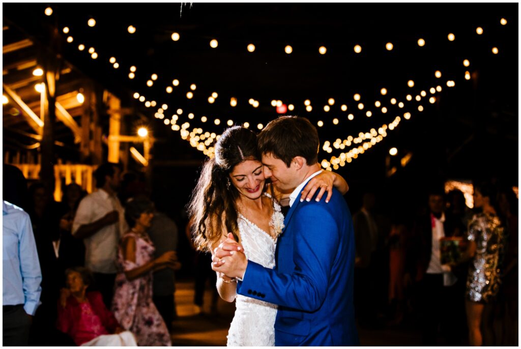 The bride and groom share their first dance under twinkle lights at the Ithaca Farmer's Market.