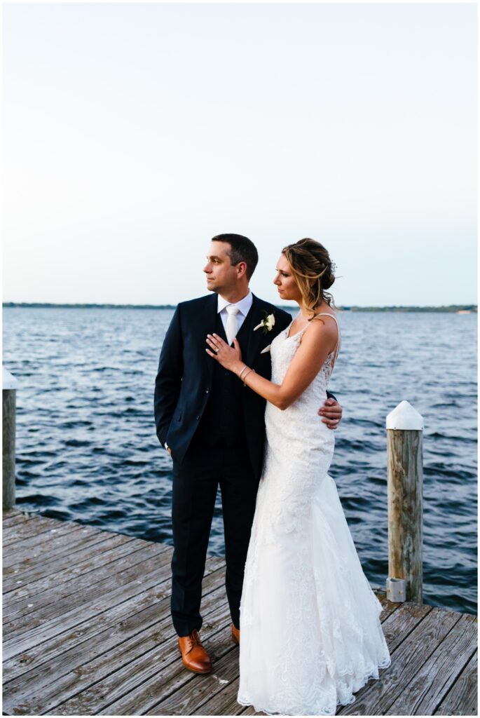 bride and groom look out at Seneca lake as they celebrate their wedding at belhurst castle.