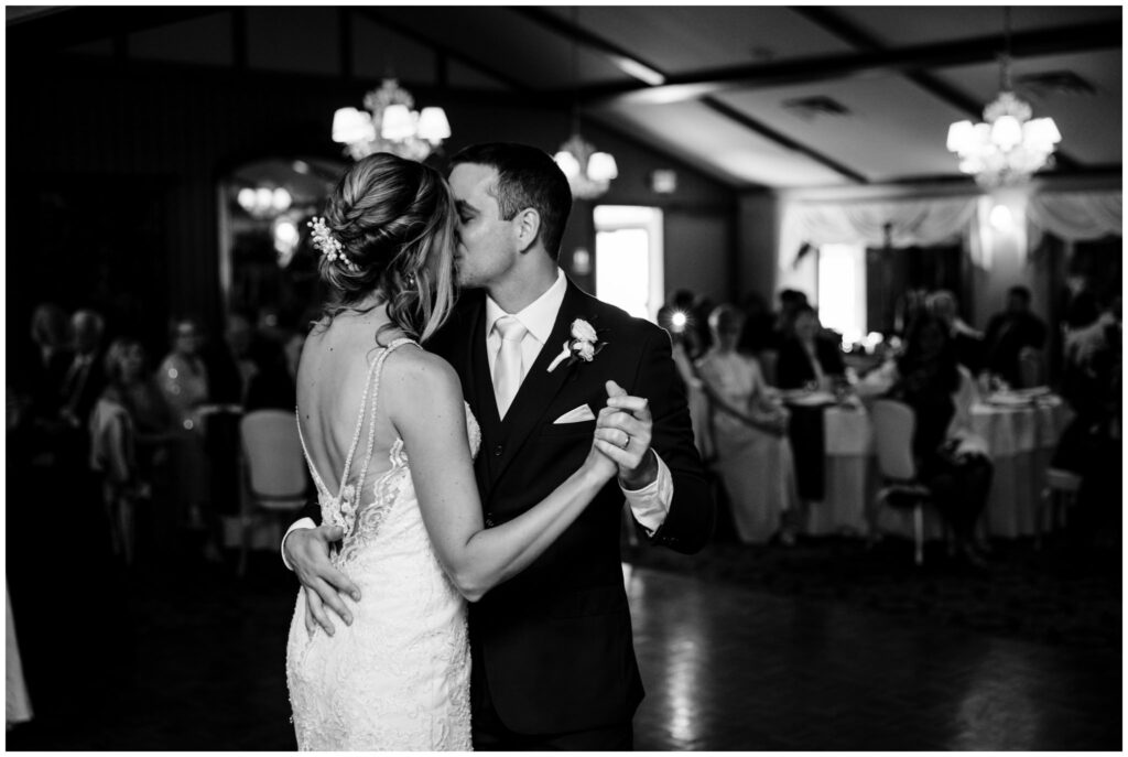 Bride and groom share a kiss on the dance floor of their wedding.