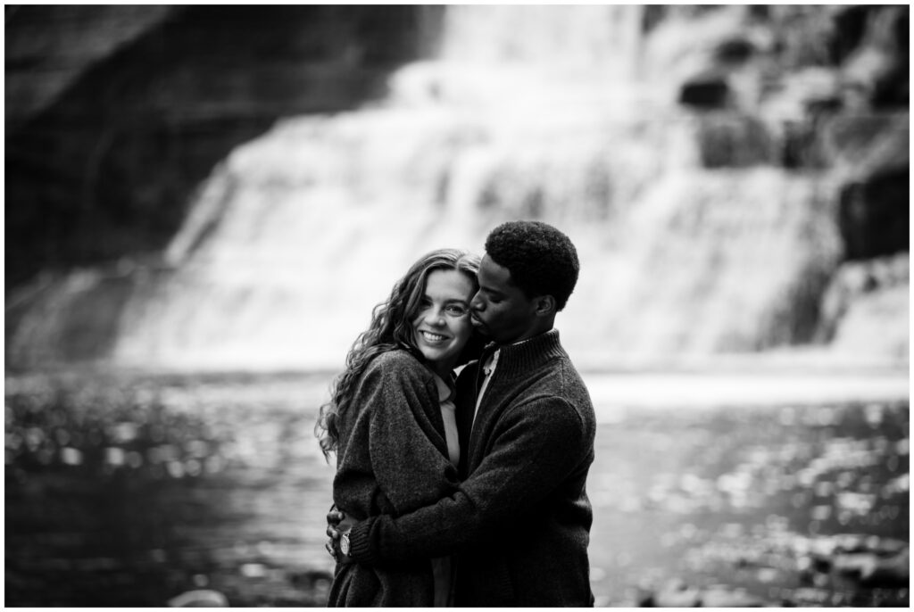couple in front of Ithaca falls hugging