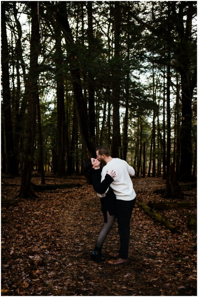 A couple kisses in the middle of beaver Lake in Syracuse, new york during their engagement session.