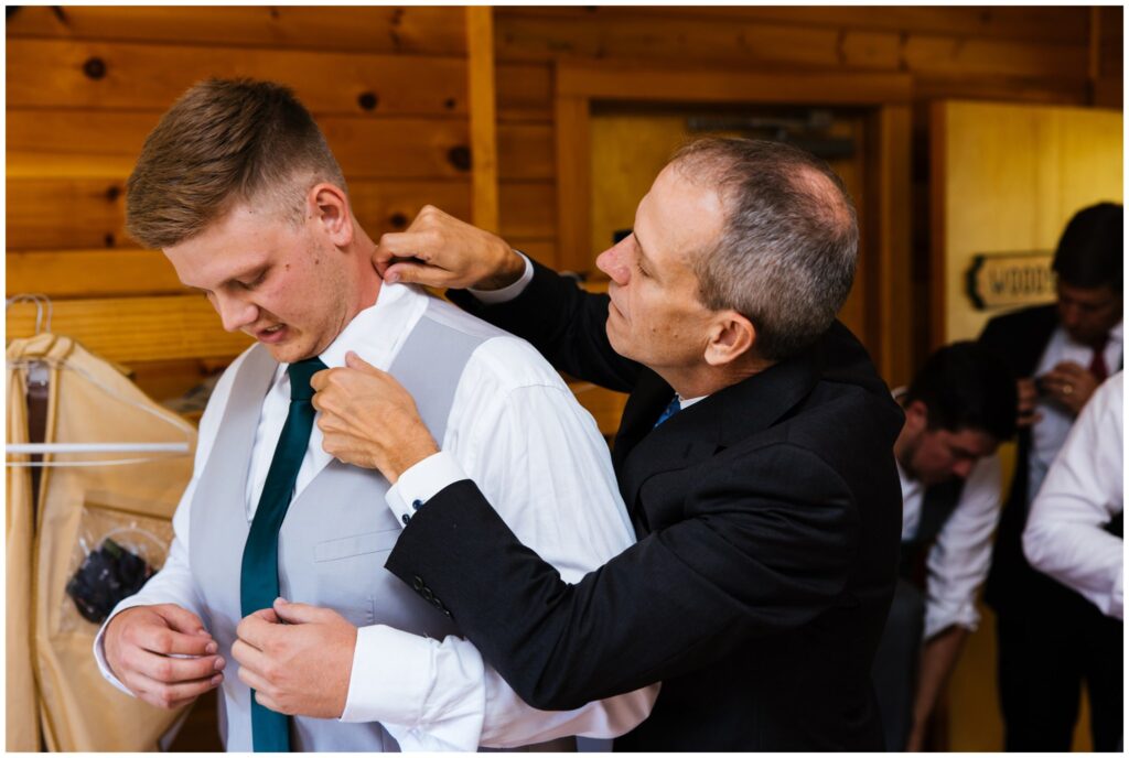 Groom is helped by his father on his wedding day.