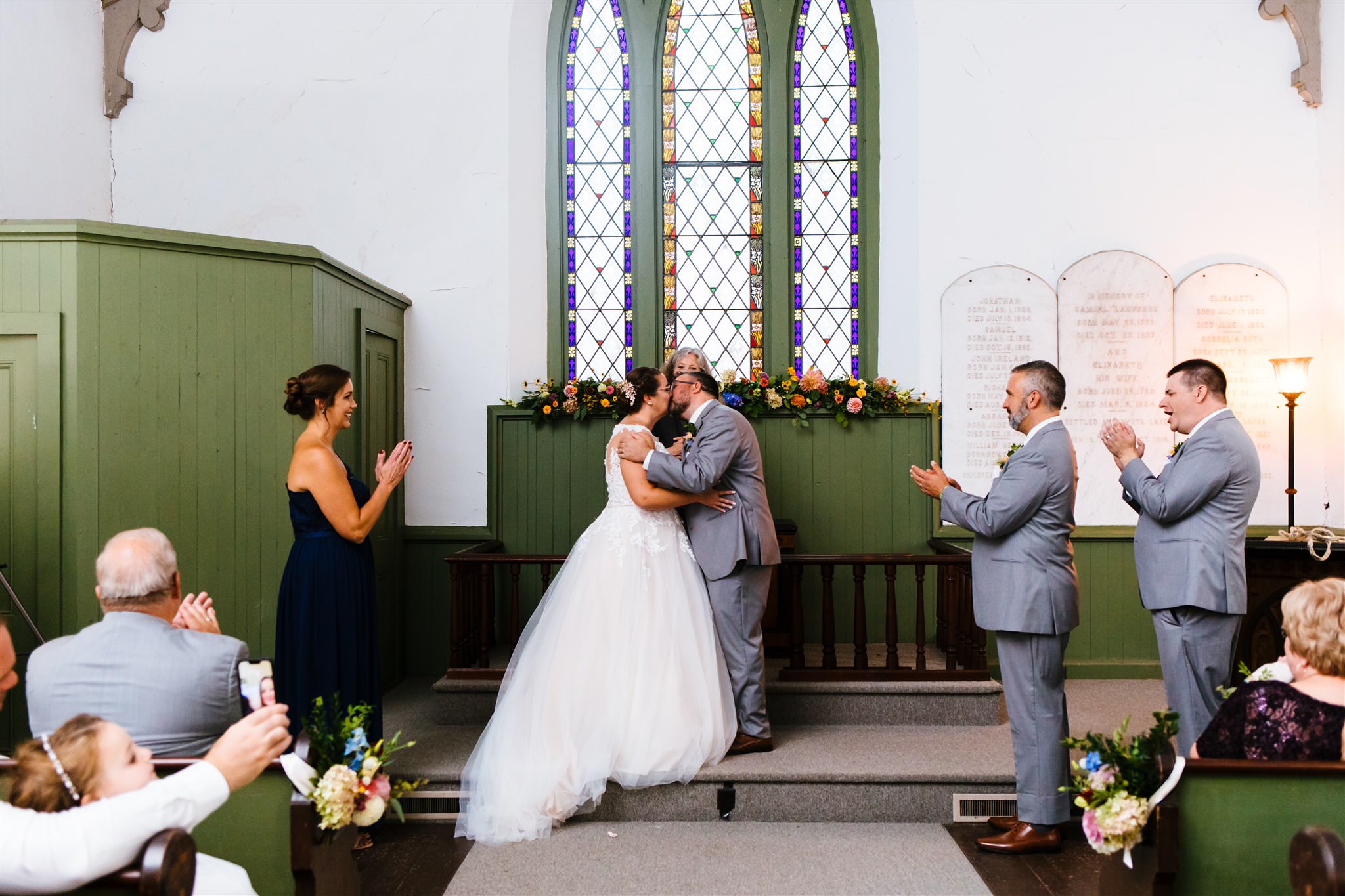 The bride and groom share their first kiss during their finger lakes wedding.