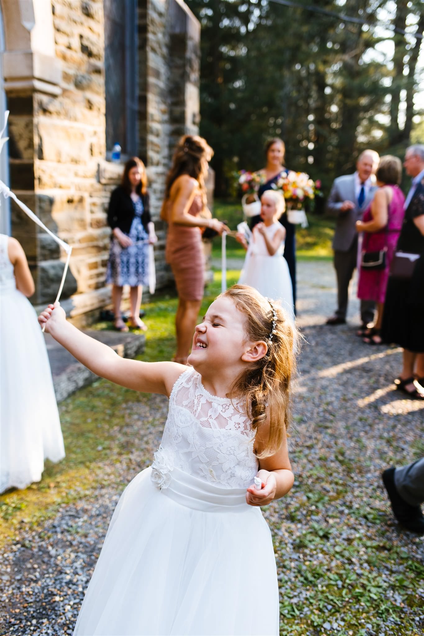 The flower girl waves a flag with glee after the wedding ceremony.