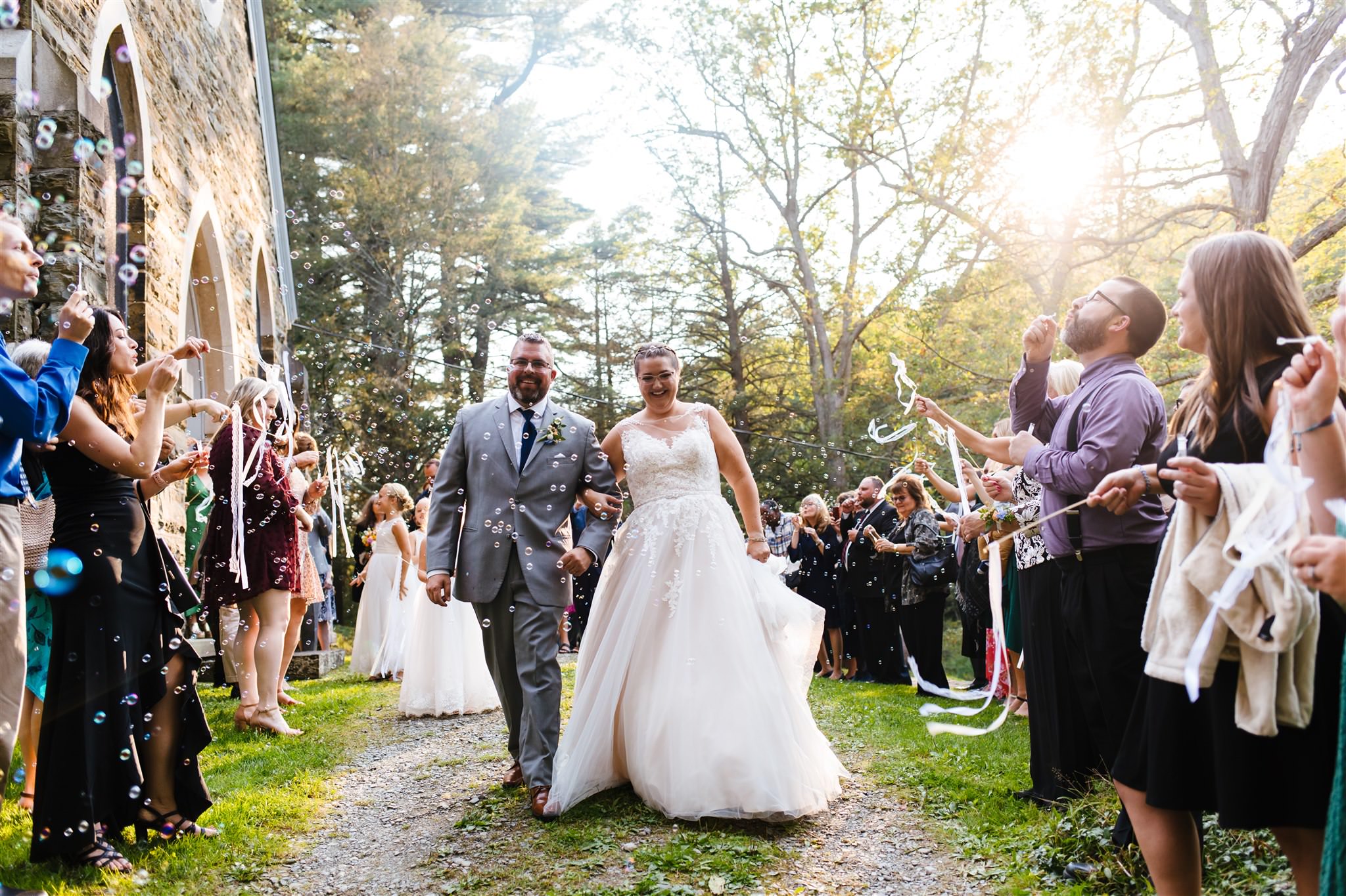 The bride and groom exit the chapel at the Fountainebleau Inn as guests blow bubbles at them.