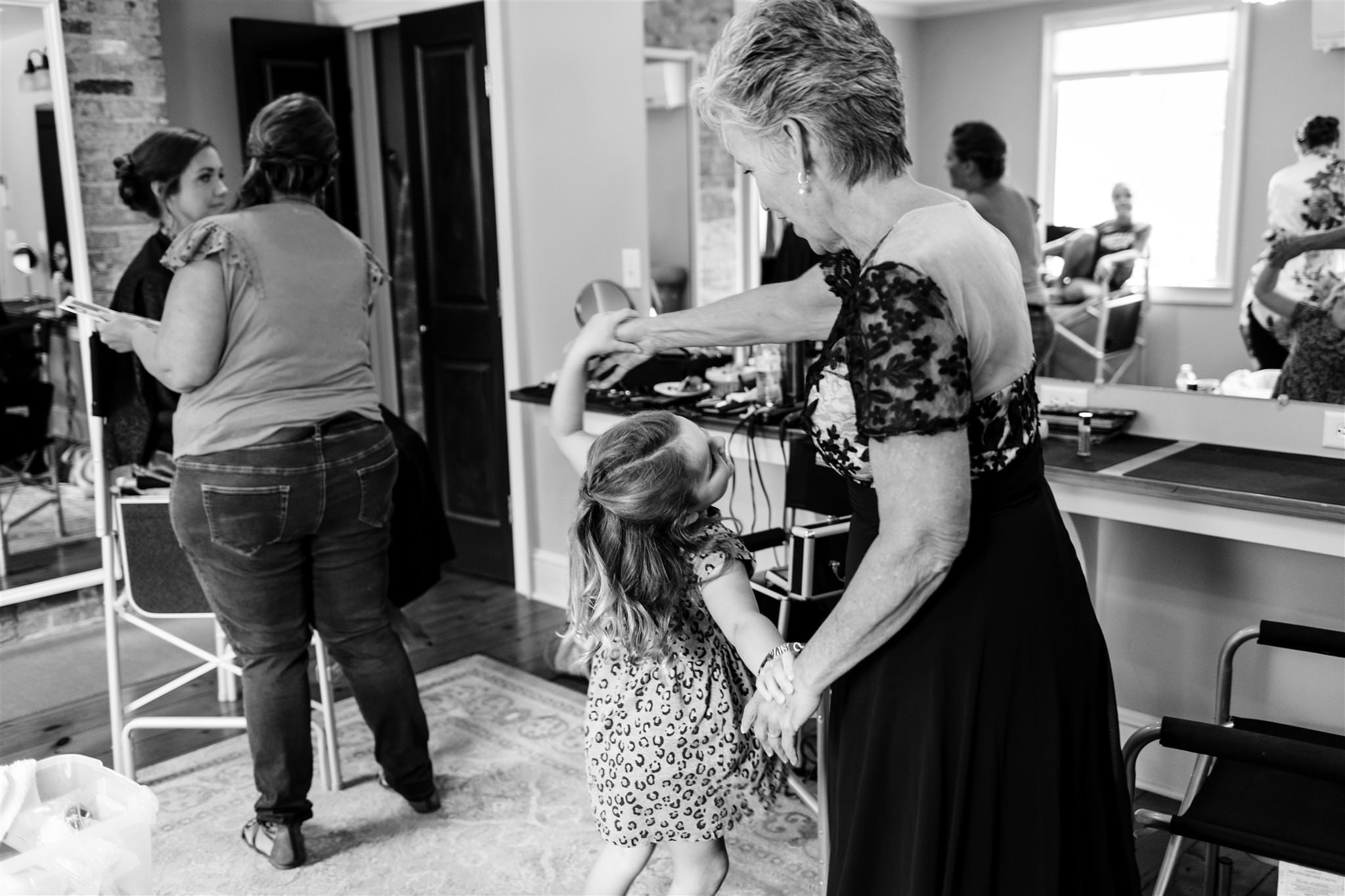 The mother of the bride and a flower girl dance in the getting ready room of the Fontainebleau inn.
