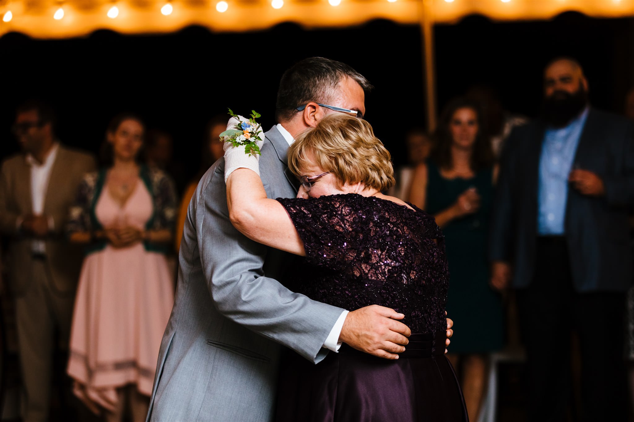 The groom and his mother share a first dance under a tent at their finger lakes wedding. 