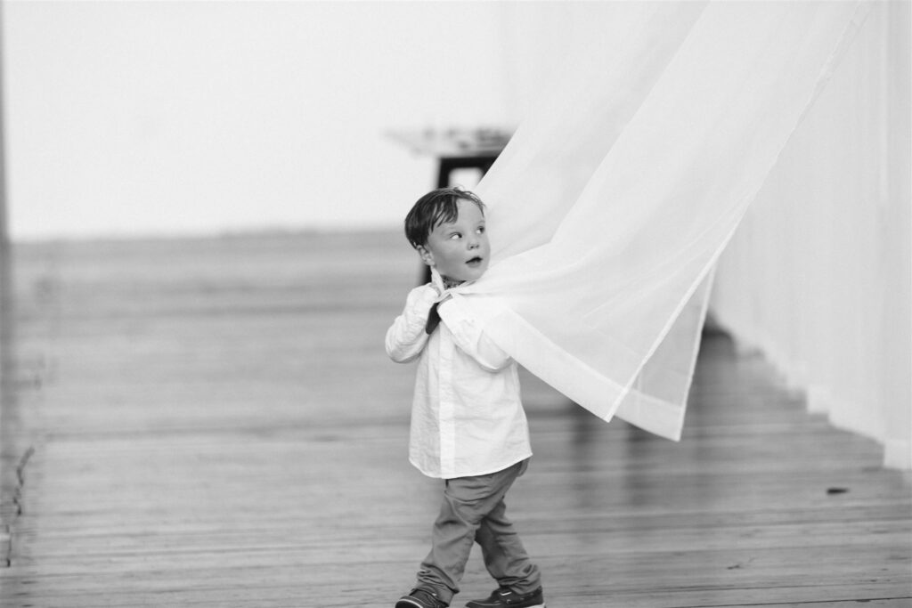 Child plays with curtains at a greylock works wedding.