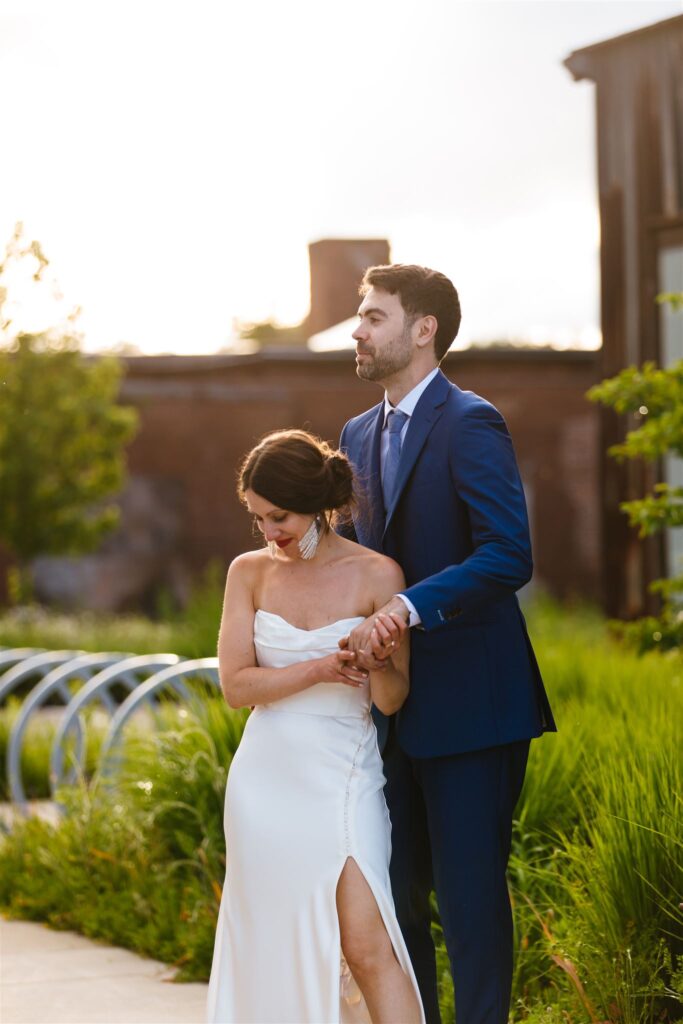 Bride and groom hug during golden hour outside at their greylock works wedding.