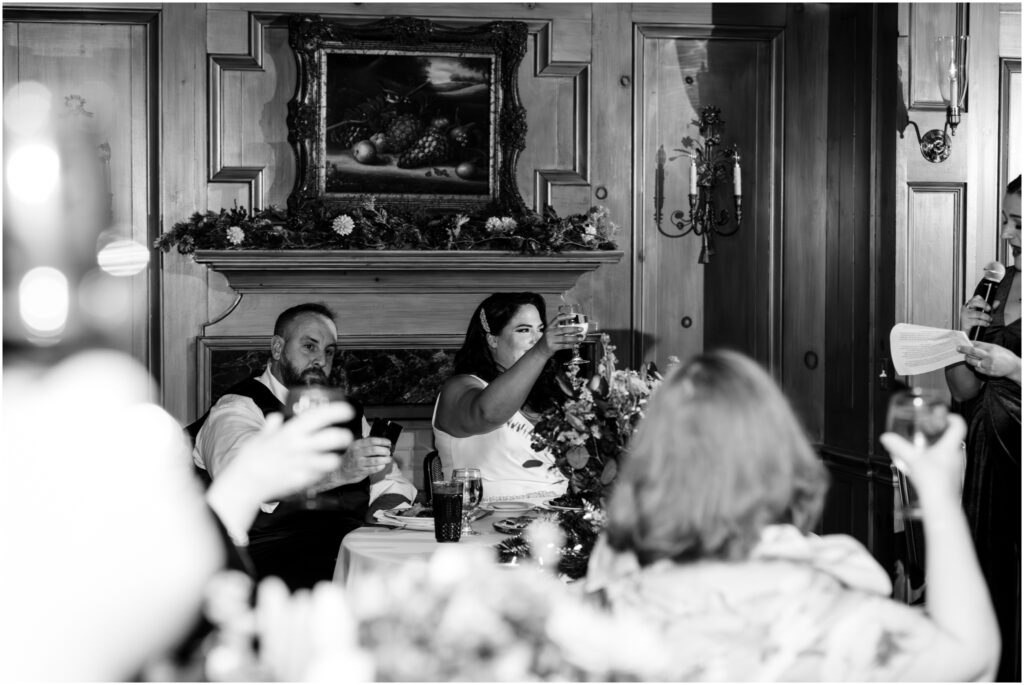 Bride and groom raise a glass during a toast at their wedding.