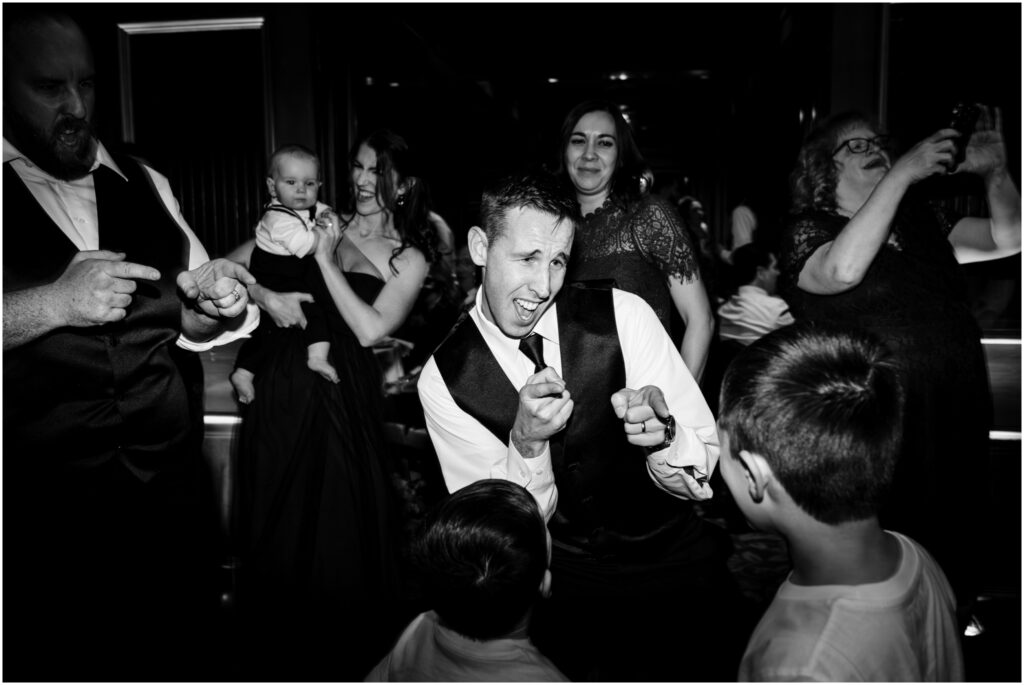 Groomsman dances at a wedding reception.