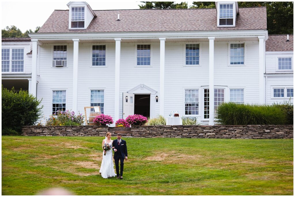 Bride walks down the lawn of the Fontainebleau Inn with her father.