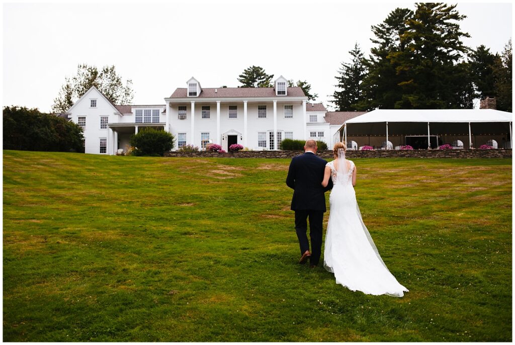 Bride and groom walk up the lawn to the Fontainebleau Inn