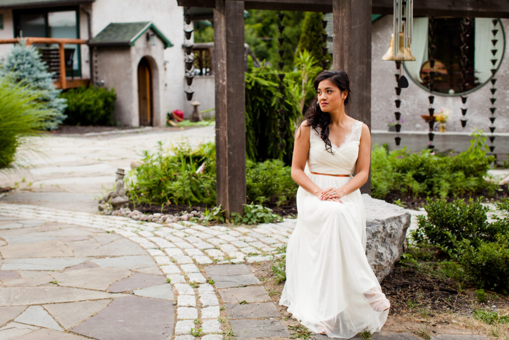 A bride sits among unique art at New Park Venue in Ithaca NY. There are many finger lakes wedding venues here. 