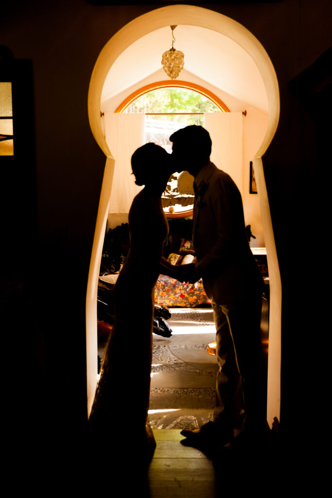 Silhouette of bride and groom in a keyhole shaped door.