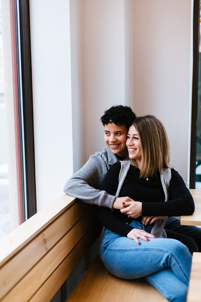 Syracuse wedding photographer, Calypso Rae Photography, took an image of a bride and bride sitting together in Sweet Praxis during their Syracuse engagement session