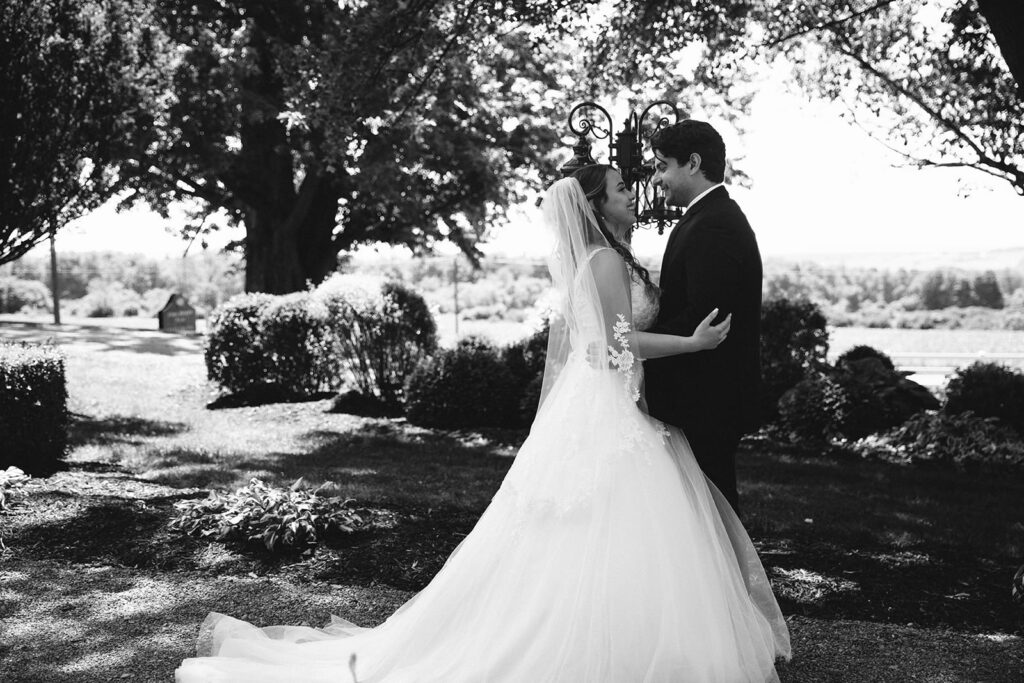 Bride and groom embrace in the lawn of the John Joseph Inn