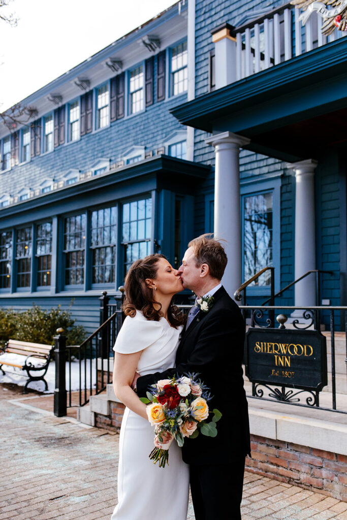 A couple kisses in front of the Sherwood Inn in Skaneateles NY. This is one of many beautiful finger lakes wedding venues.