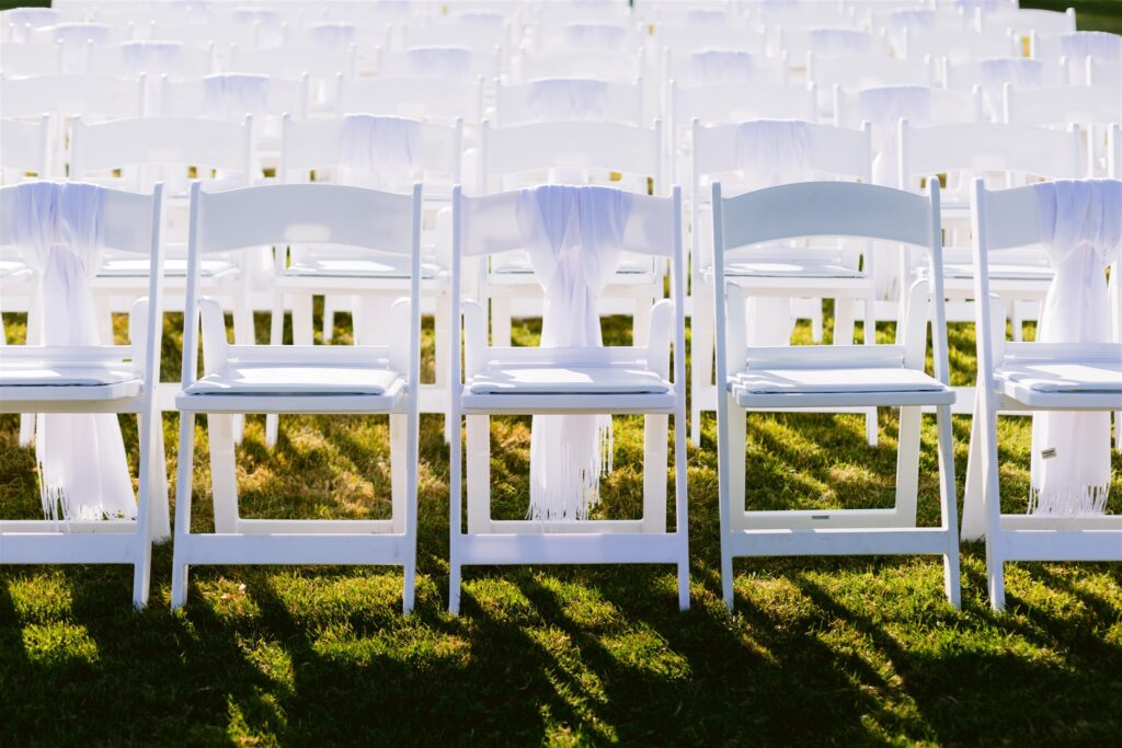 Wedding chairs are adorned with scarves for wedding guests.