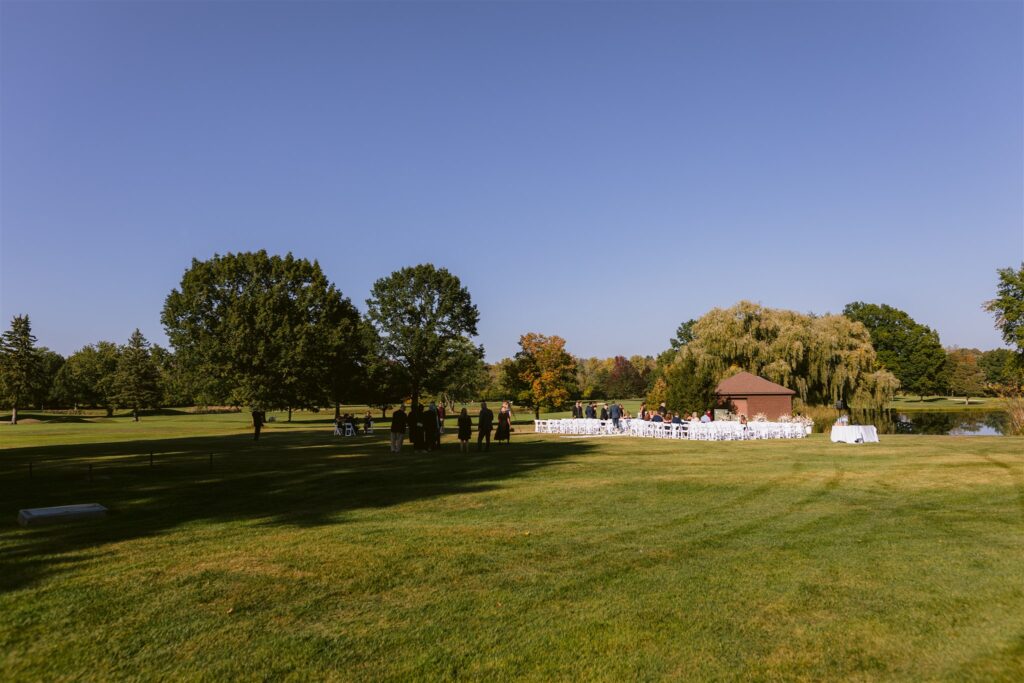 Guests mingle at the ceremony site at a locust hill country club wedding.