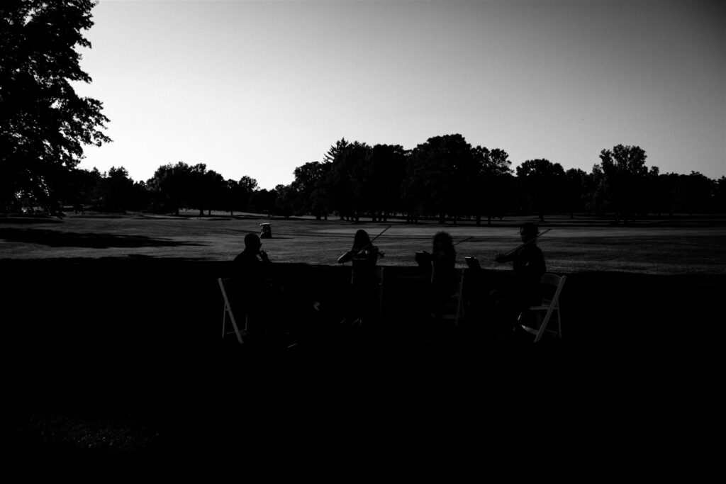 Silhouette of musicians playing at their locust hill country club wedding.