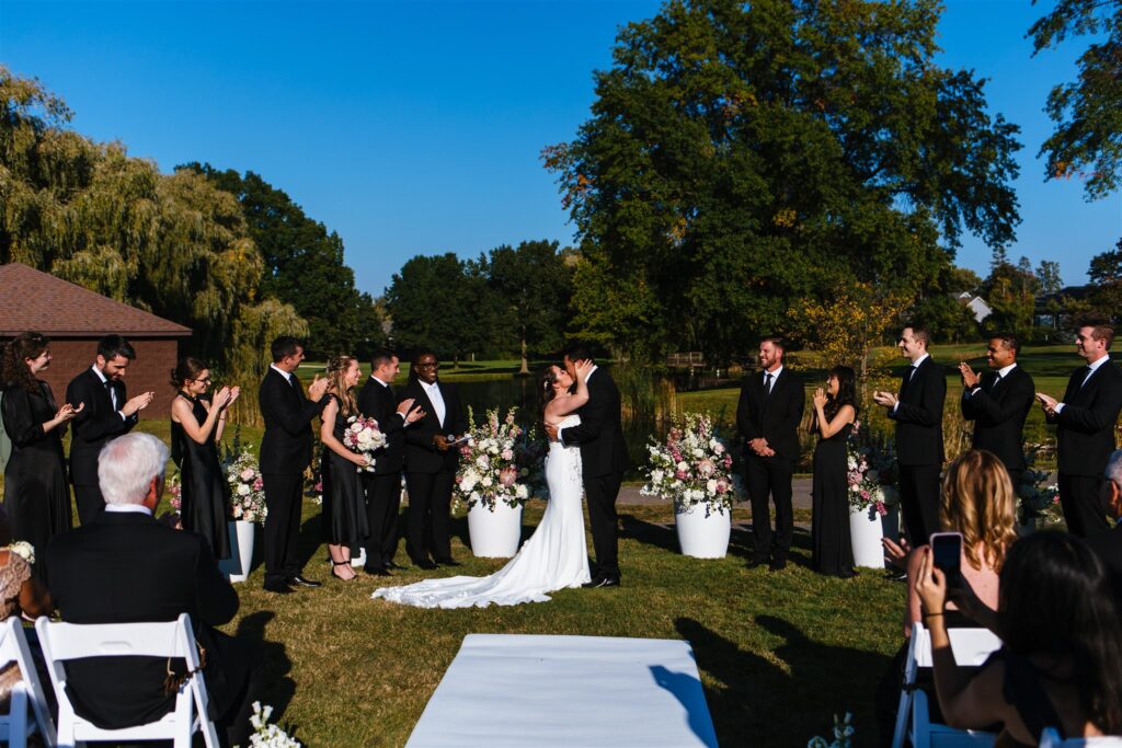 Bride and groom share a first kiss at their Locust Hill country club wedding ceremony. They were married in late September in Rochester, NY.