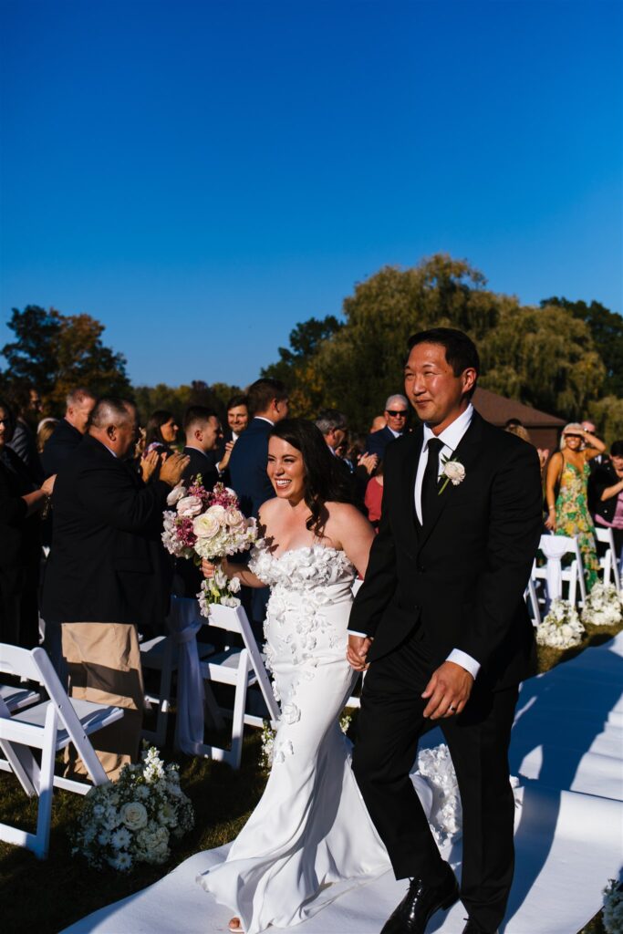 Bride and groom walk down the aisle after their wedding ceremony in Rochester, NY.