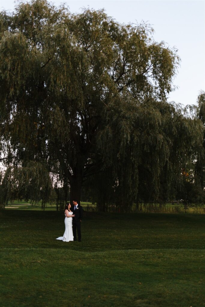 Bride and groom are under a willow at their Rochester, ny wedding in September.