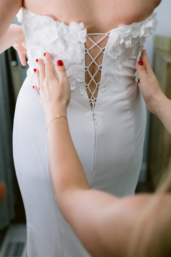 A stunning detail photo of the bride's dress with white flowers on it.