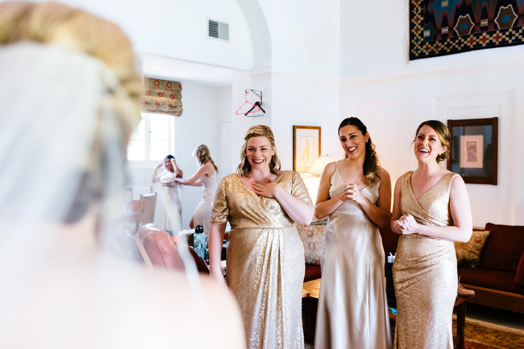 Wedding party smiling at a bride in a wedding dress 