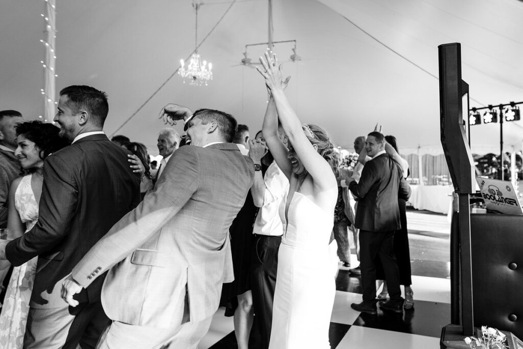 People dancing at a wedding reception with a newlywed couple 