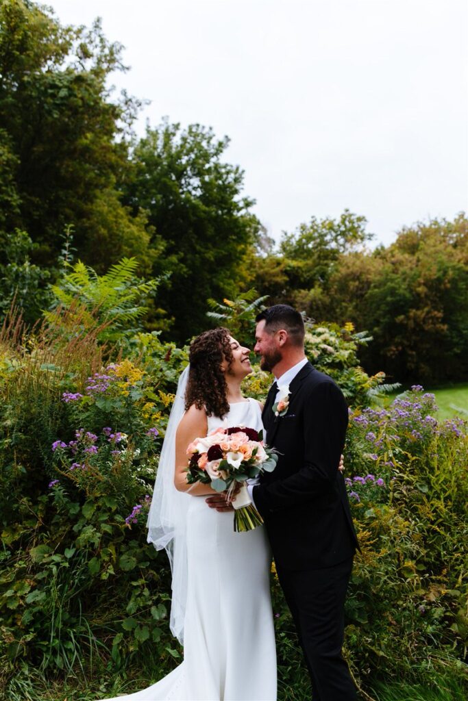 A newlywed couple standing close together about to kiss. 