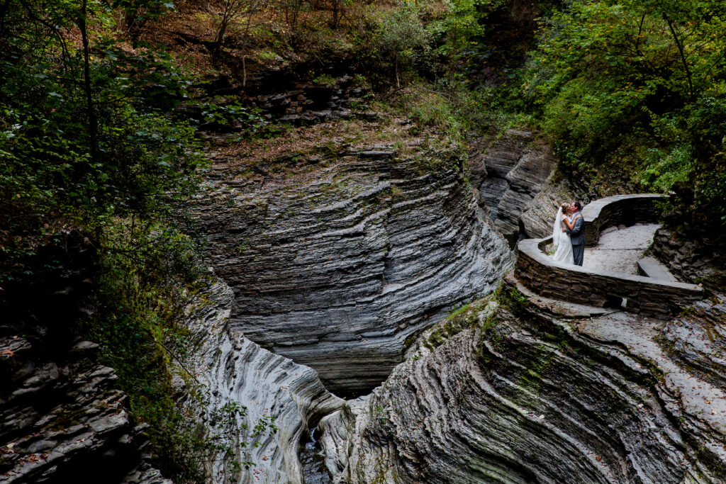 A bride and groom share a kiss at the gorges of Watkins Glen in upstate, NY.