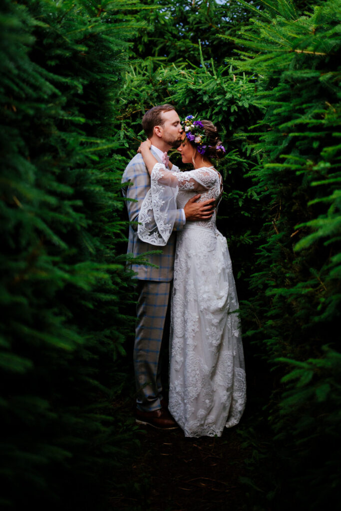 The bride and groom share a romantic kiss in the middle of a maze. 