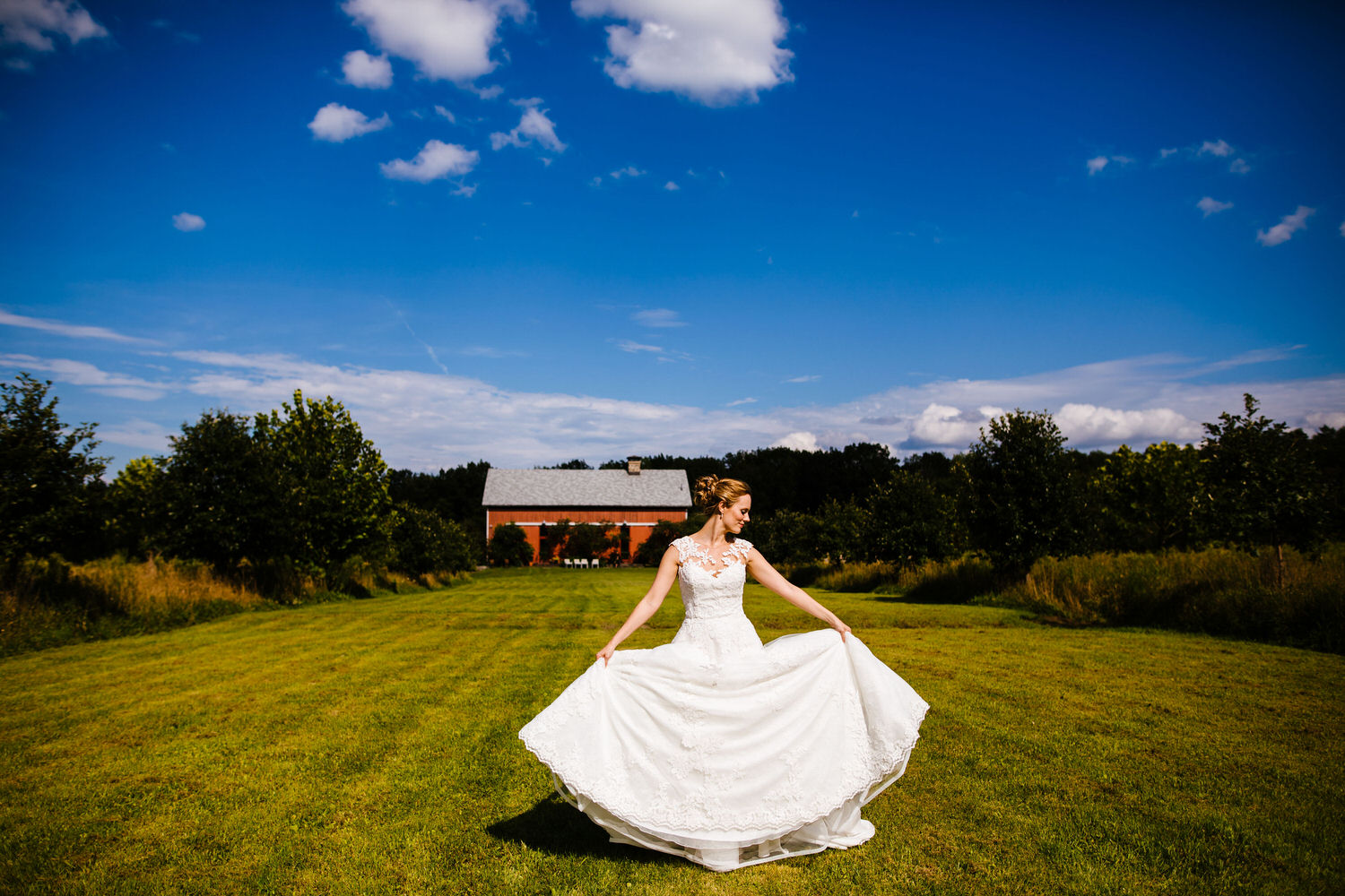 A person stands in a wedding dress in front of a wedding venue in Central NY.