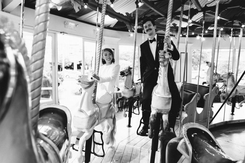 Bride and groom ride on an antique carousel during their Saratoga springs wedding.